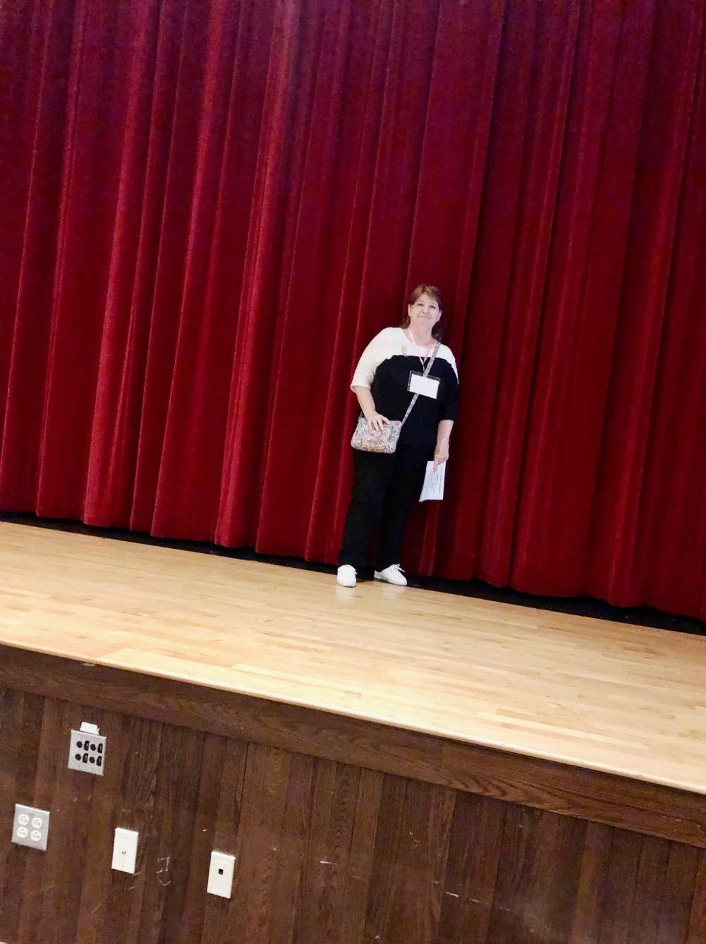 Cheryl Hibbard Gourley on stage in the auditorium