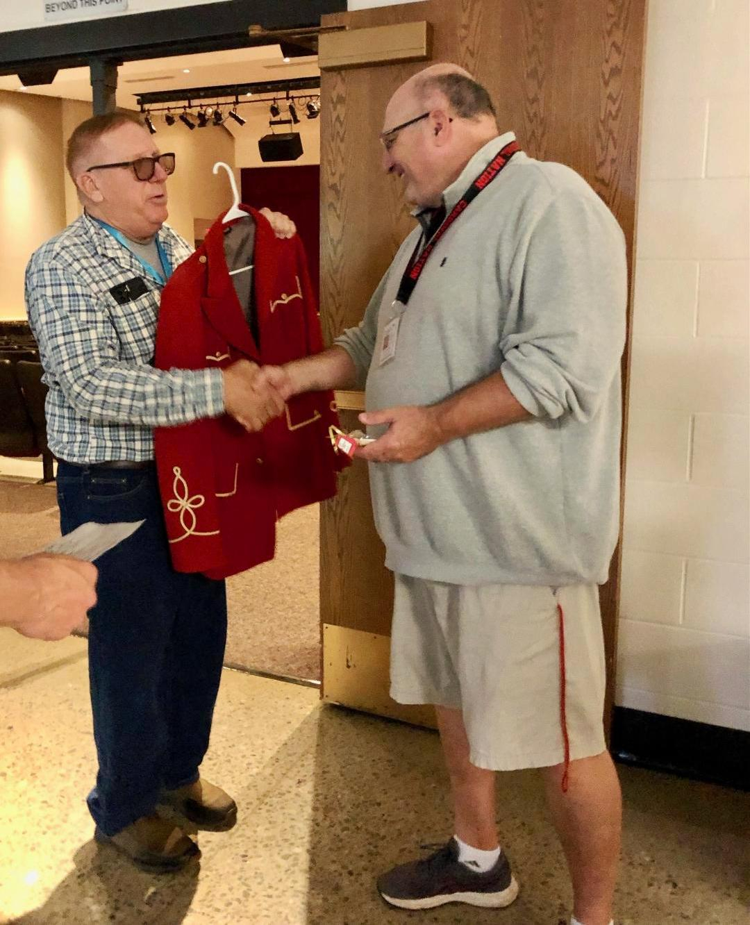 Bill Granger presenting Principal Ed Mertson with a vintage NVCS Marching Band jacket